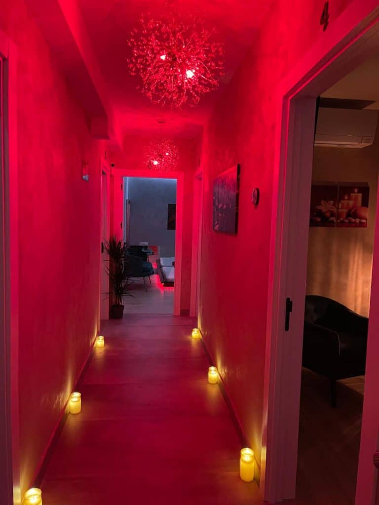 Pasillo iluminado con luces rojas y velas decorativas