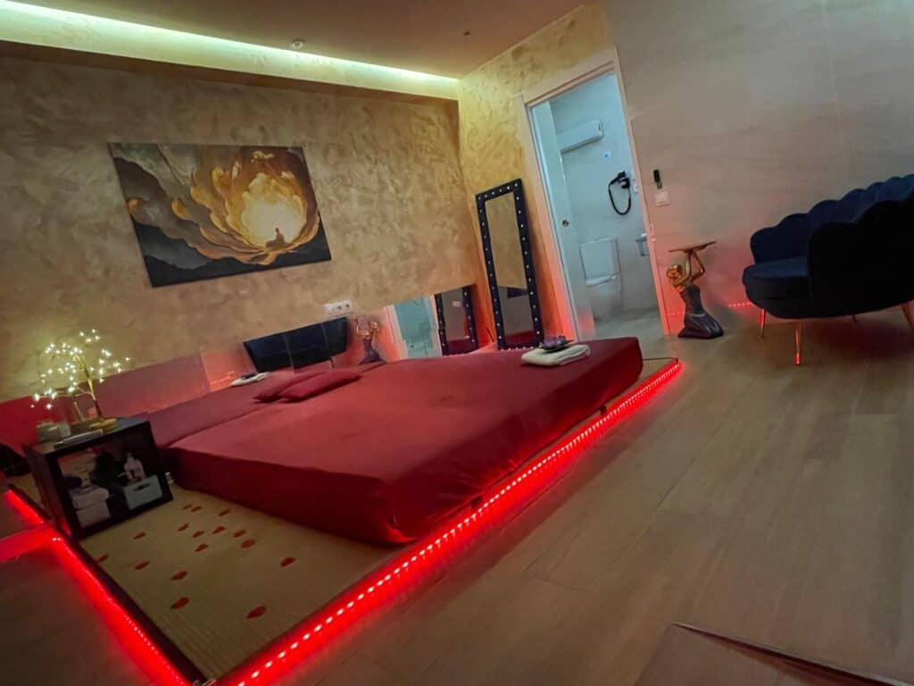 Habitación romántica con cama roja y luces LED